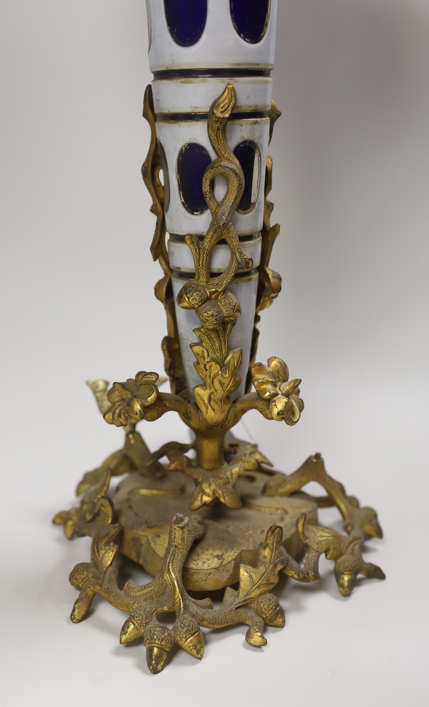 A 19th century Bohemian overlaid glass trumpet vase, on an ornate gilt metal stand, 44cm high